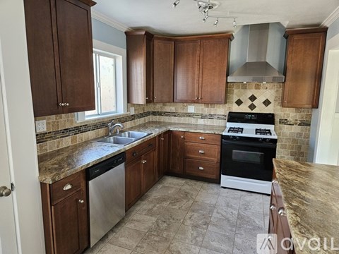 A kitchen with brown cabinets and a black stove top oven.