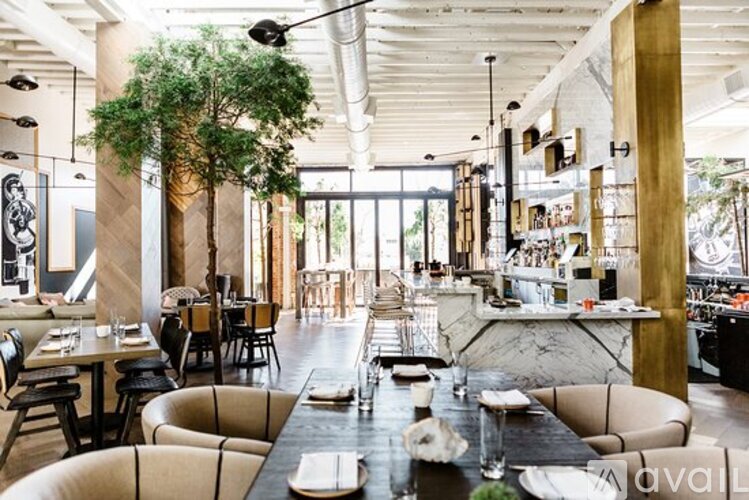 A modern dining room with a long table set for a meal.