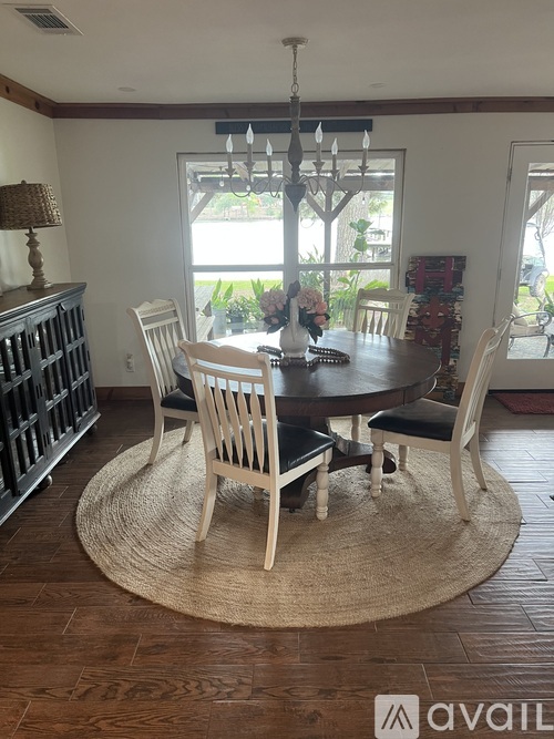 A dining room with a round table and chairs.