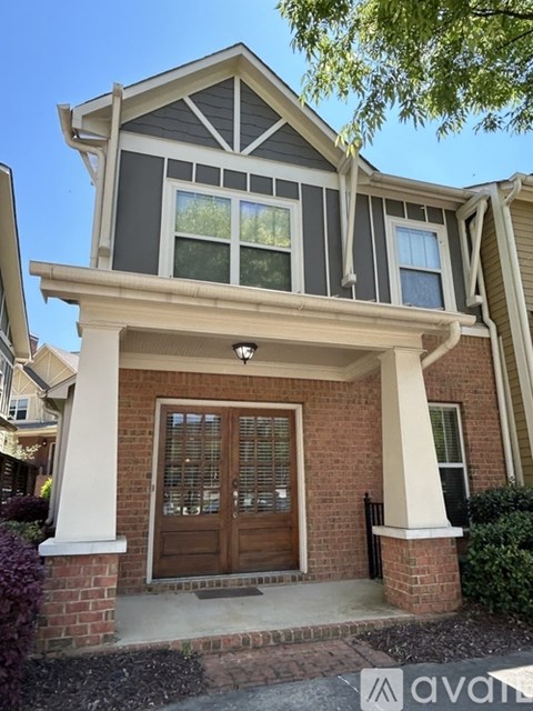 A house with a brown door and a brick base.
