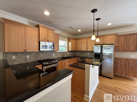 A kitchen with wooden cabinets and black countertops.