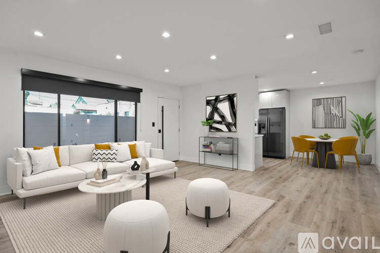 A modern living room with a white sofa and a yellow chair.