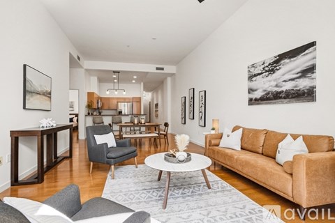 A living room with a brown couch, grey armchair, and a coffee table.