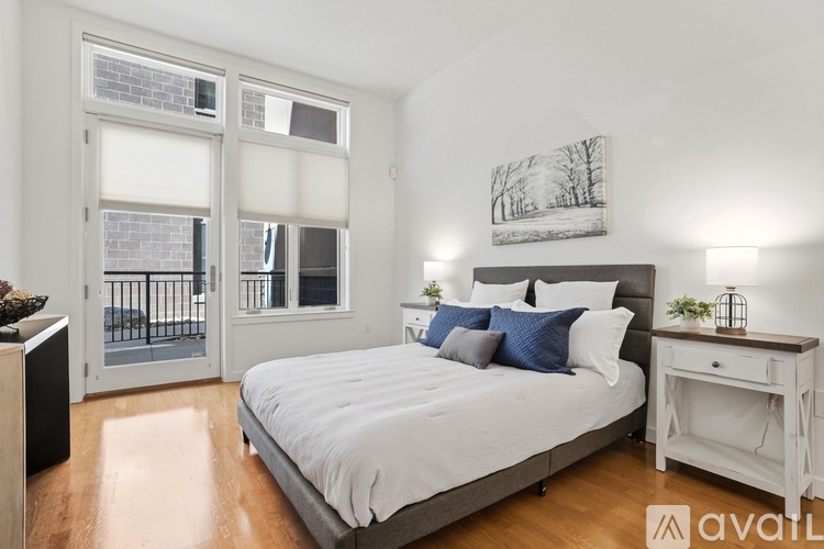 A bedroom with a bed, nightstand, and a painting on the wall.