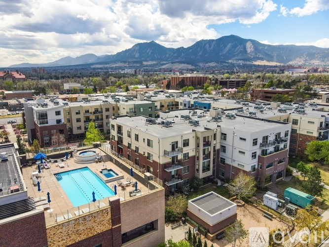 A view of apartment buildings with a pool and a mountain in the background.