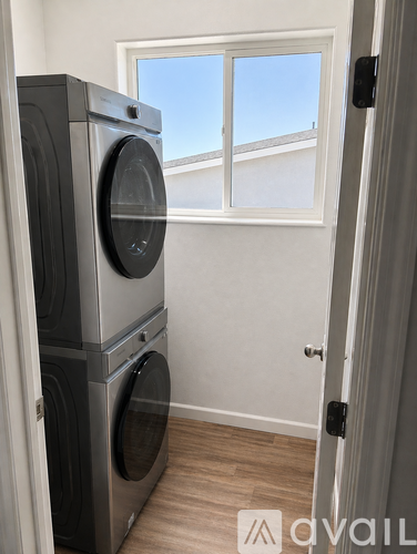 A stack of three washing machines in a laundry room.