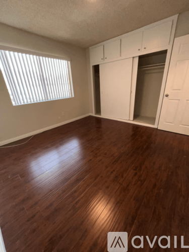 A room with wooden floors and white cabinets.