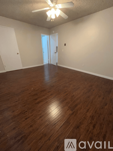 A room with wooden flooring and a ceiling fan.