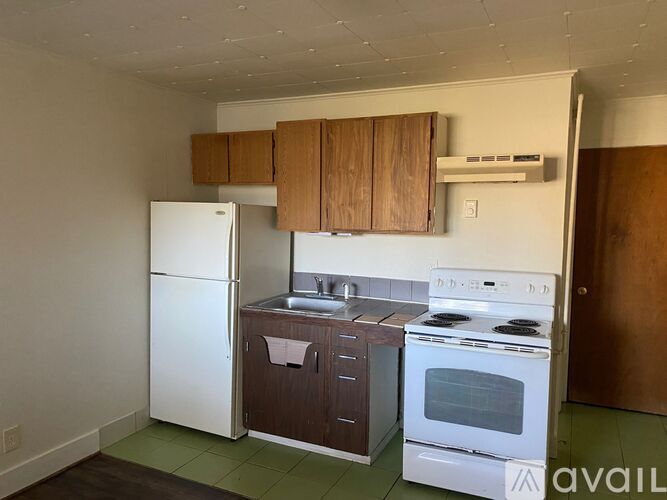 A kitchen with white appliances and brown cabinets.