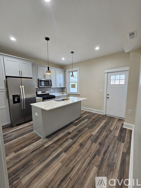 A kitchen with a refrigerator, microwave, and a countertop.