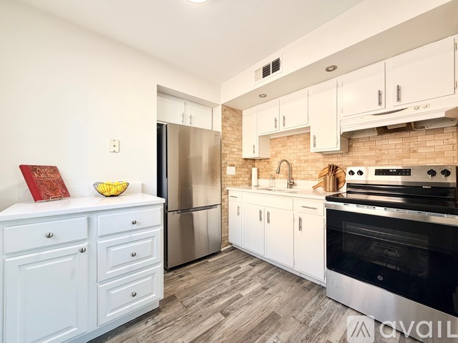A kitchen with white cabinets and a black oven.