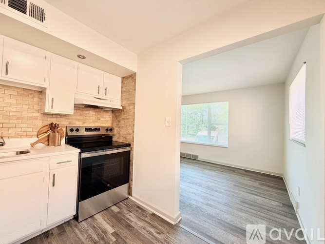 A kitchen with white cabinets and a black stove top oven.