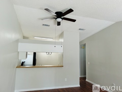 A room with a ceiling fan and a mirror on the wall.