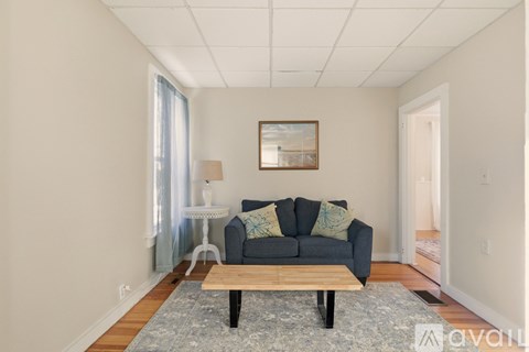 A living room with a grey couch and a wooden coffee table.