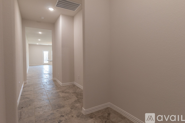 A long hallway with tiled floors and white walls.
