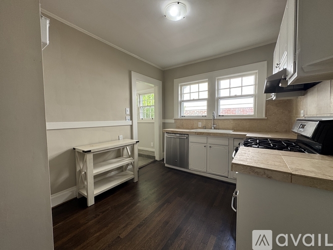 A kitchen with a stove top oven and a window.