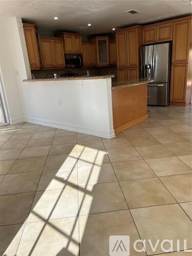 A kitchen with wooden cabinets and a white island.