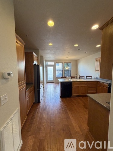 A kitchen with wooden floors and a refrigerator.