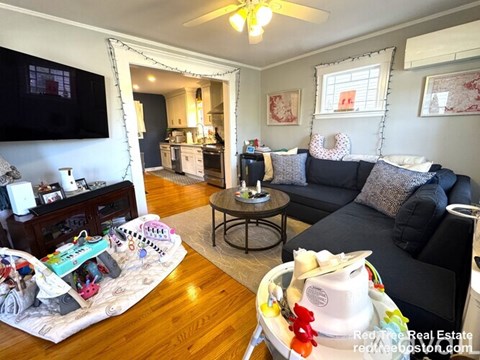 A living room with a black couch and a coffee table.