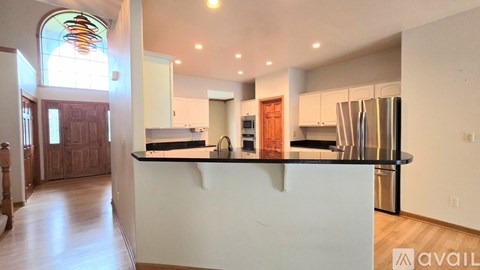 A kitchen with a white counter and a stainless steel refrigerator.