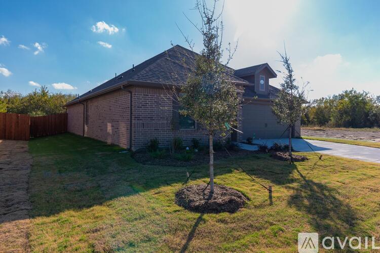 A house with a brown roof and a tree in front of it.