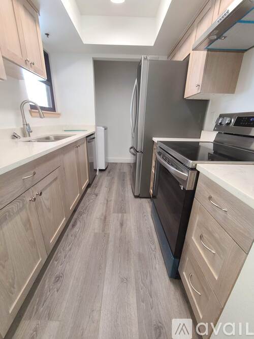 A kitchen with wooden cabinets and a black refrigerator.