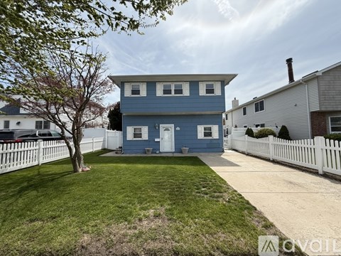 A blue house with a white fence in front.
