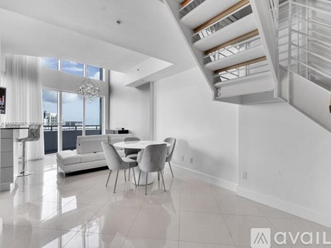 A modern living room with a dining table and chairs.