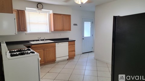 A kitchen with white appliances and wooden cabinets.