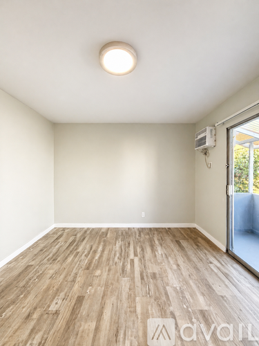 A room with wooden flooring and a window.
