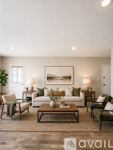A living room with a large painting on the wall and a coffee table in the center.