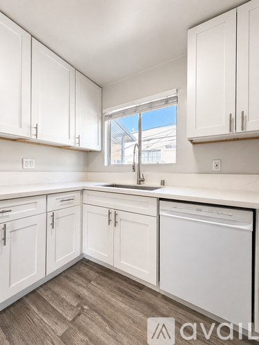 A kitchen with white cabinets and a washing machine.