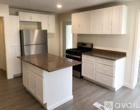 A kitchen with white cabinets and a brown countertop.