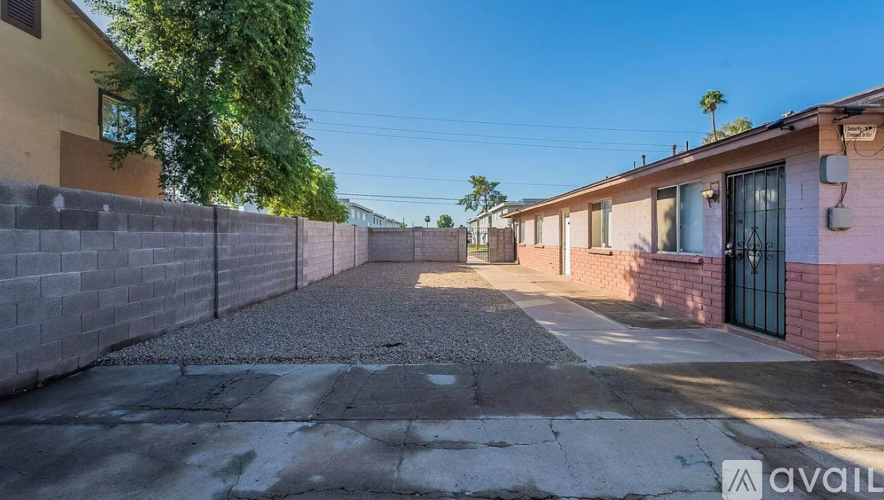 A sunny day in a residential area with houses on either side of a paved alley.