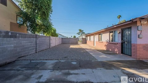 A sunny day in a residential area with houses on either side of a paved alley.