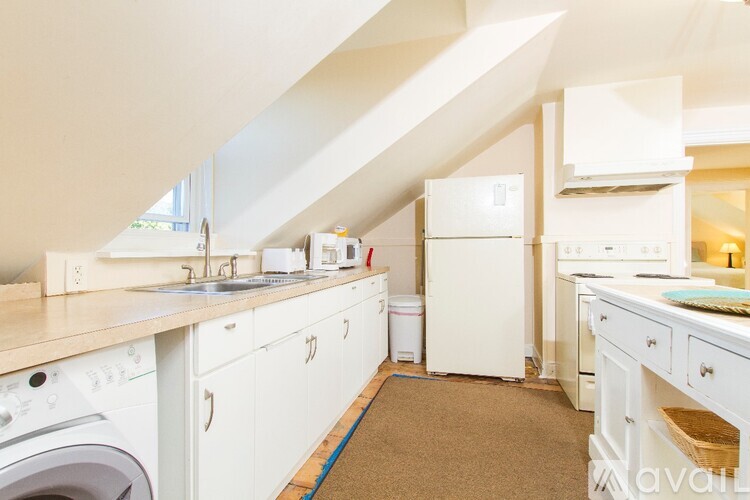 A kitchen with white appliances and cabinets.