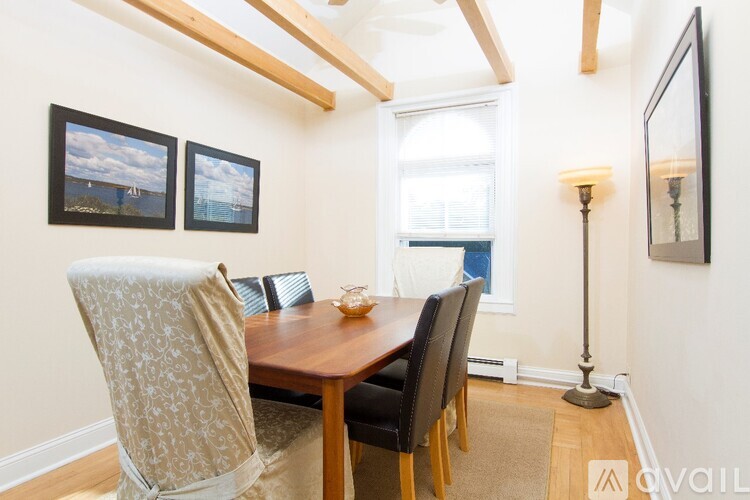A dining room with a wooden table and chairs.
