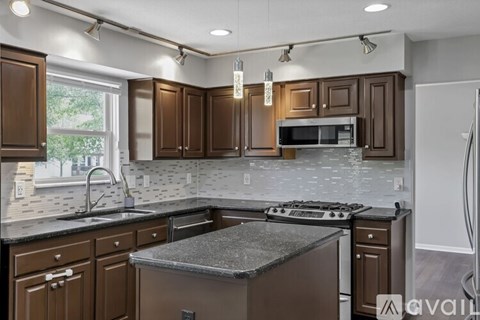 A kitchen with brown cabinets and a granite countertop.