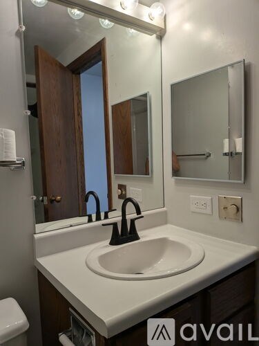 A bathroom with a sink, mirror, and lights.