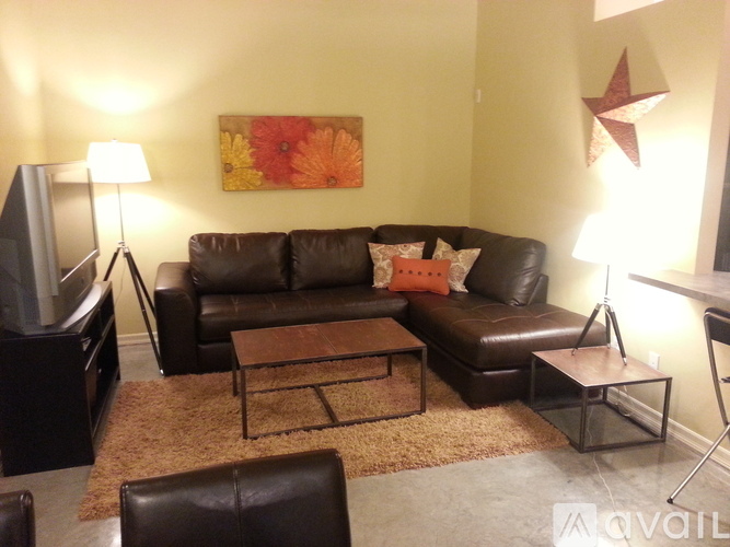 A living room with a brown leather couch and a coffee table.