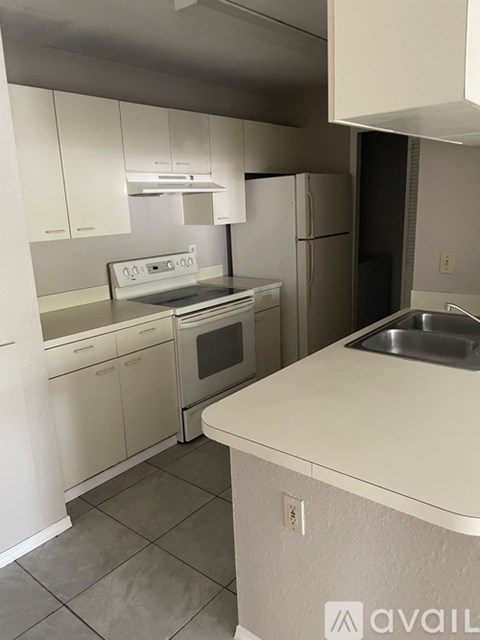 A kitchen with white cabinets and a stainless steel refrigerator.
