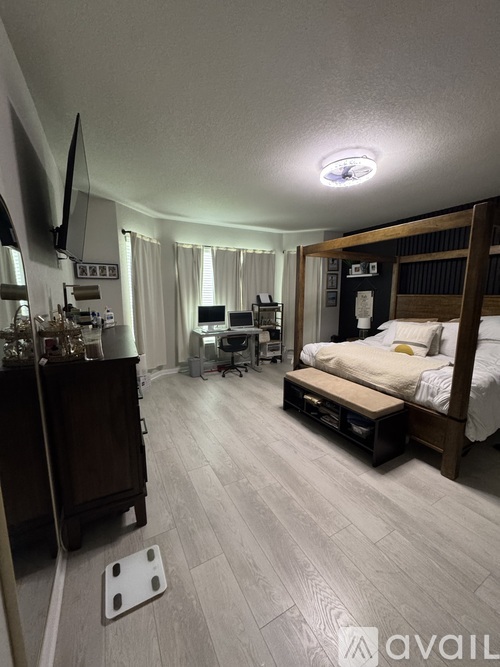 A bedroom with a bed, desk, and chair.