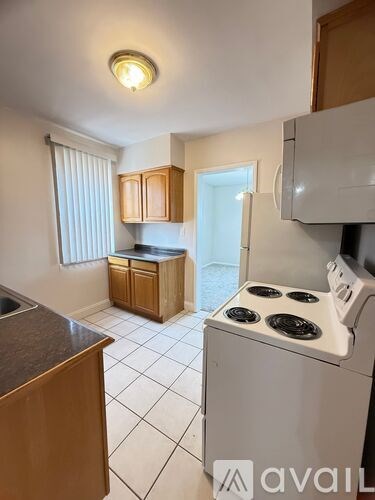 A kitchen with a white stove top oven and a white dishwasher.