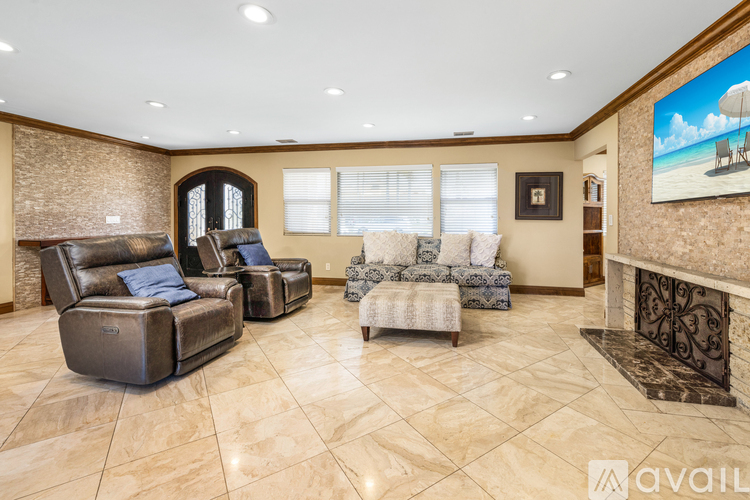 A living room with a fireplace and a painting of a beach scene on the wall.