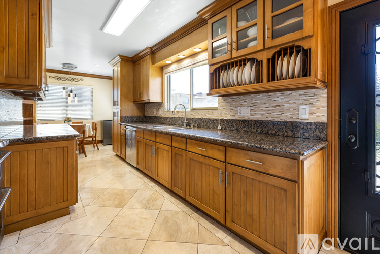A kitchen with wooden cabinets and a granite countertop.