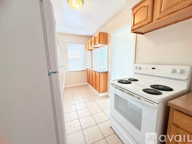 A kitchen with a white stove and a white refrigerator.