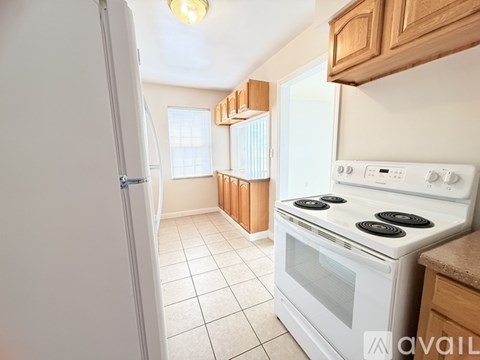 A kitchen with a white stove and a white refrigerator.