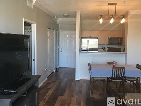 A living room with a television and a dining table.