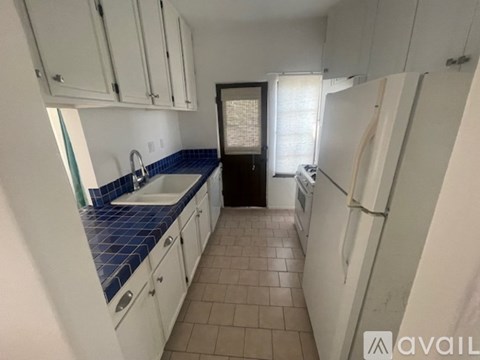 A kitchen with white cabinets and a blue tile backsplash.
