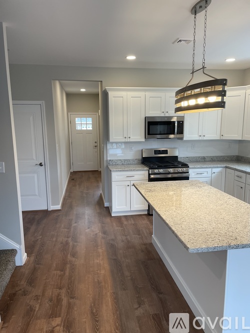 A kitchen with white cabinets and a granite countertop.